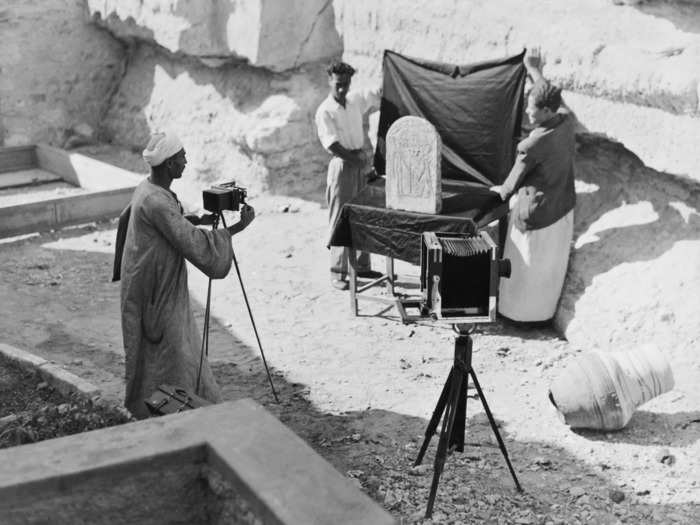 1925: A group of archaeologists photograph a funerary stele, which is a monument to the deceased.