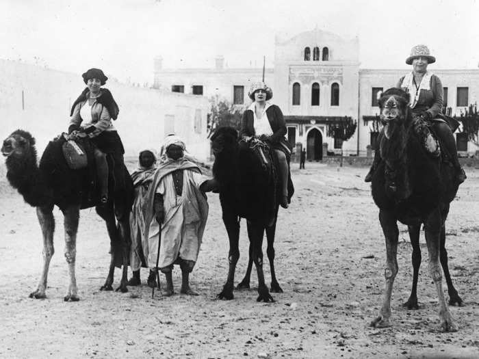 1922: A group of American, English, and French tourists try riding camels in the Sahara.