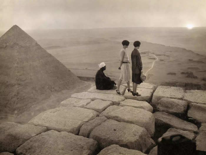 1920: A group of tourists gaze at the Sahara Desert from the top of the Great Pyramid of Giza, which is the tomb of pharaoh Khufu.