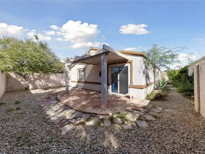 The home has a covered patio area outside and a backyard.