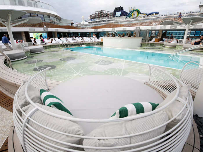 Two hot tubs and showers surrounded the swimming hole while leaf-like structures partially shaded the circular above-water daybeds.