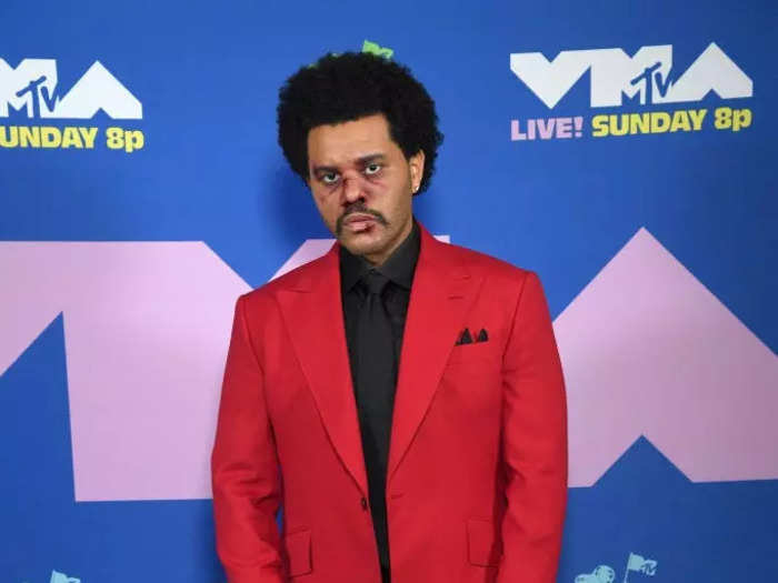 The Weeknd in a red suit, complete with a bloody nose.