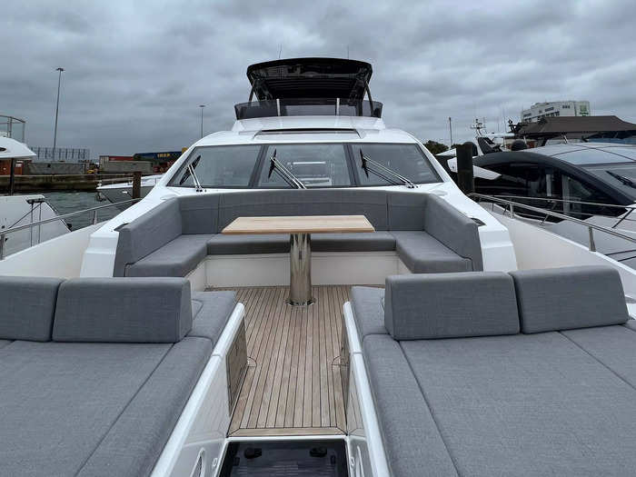 The front features a u-shaped booth similar to the flybridge, as well as some cushioned sun loungers.