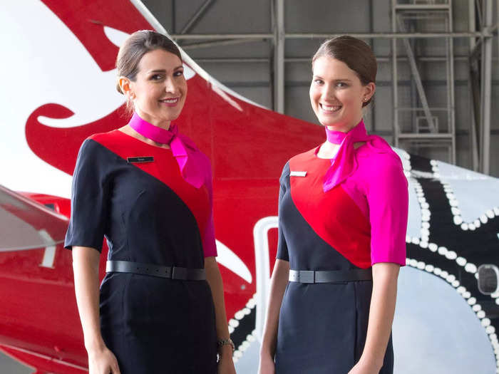 Today, Qantas flight attendants wear belted navy-blue dresses with ruby-red and fuchsia stripes.