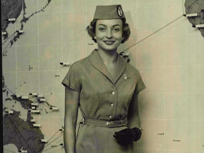 In 1959, Qantas flight attendants wore belted short-sleeved dresses.