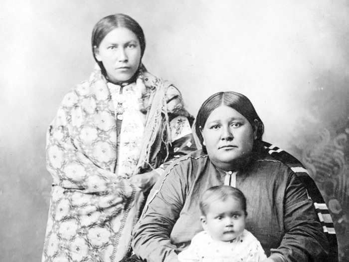 Circa 1918: A woman and her two children are photographed in Pawhuska. New York City residents can see an Osage blanket like this one in the Metropolitan Museum of Art.