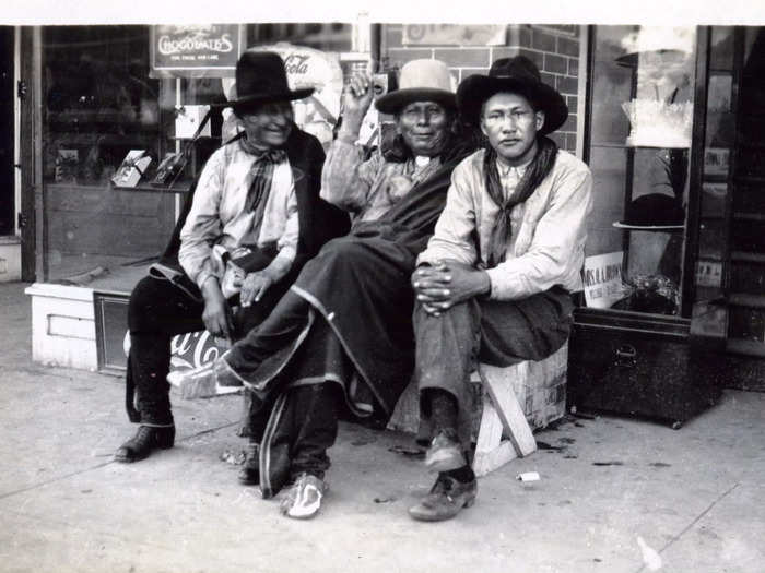 Circa 1918: But most photos show the tribe members decades later. This photo shows three members of the Osage Nation sitting in front of a shop in Pawhuska, the city where the Osage tribal government still operates today.