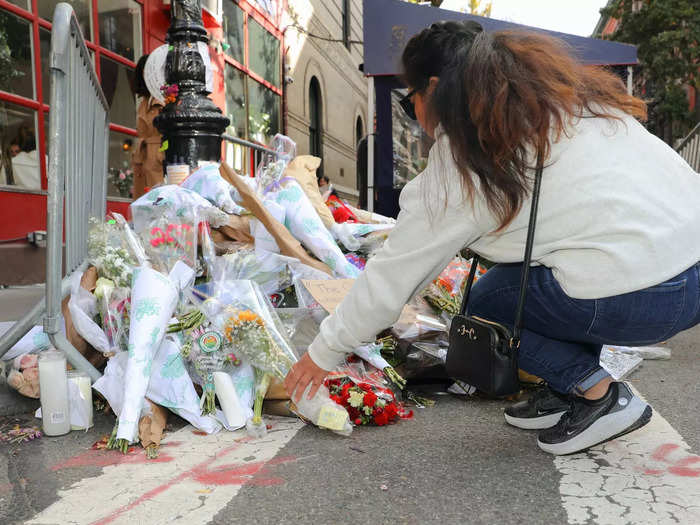 Fans left flowers next to a lamppost outside the building.