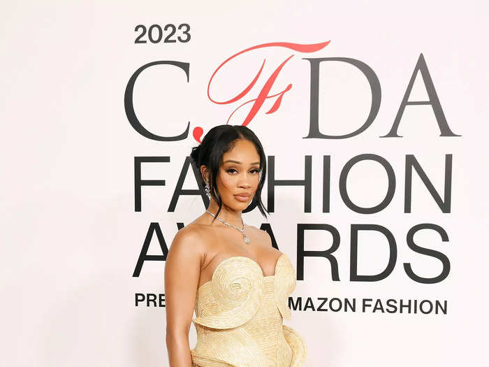 Saweetie stood out in a woven Cult Gaia gown with oversized spirals and daring side cutouts.