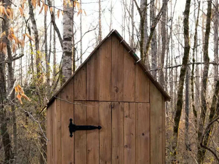 The tiny glass house also comes with an outhouse with a composting toilet that doesn