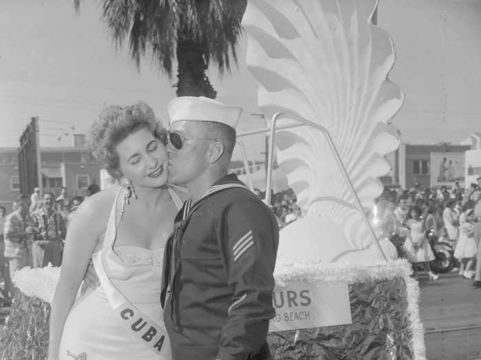July 17, 1955: Miss Cuba sneaks a kiss from a sailor who was part of security at the Miss Universe parade.