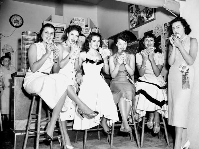 July 14, 1953: Six Miss Universe contestants grab hot dogs before the competition in Long Beach, California. For some of them, it