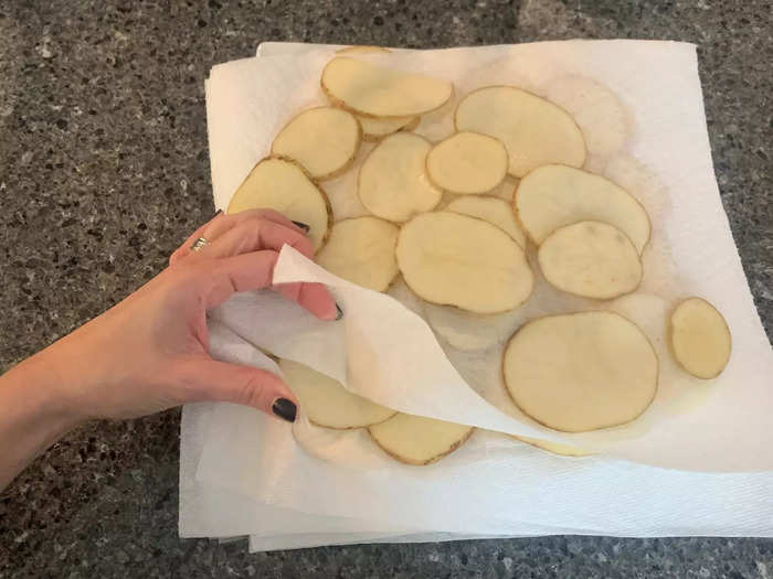 After slicing, the potatoes are soaked in cold water and thoroughly dried. 