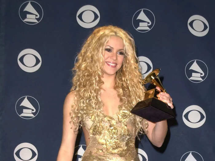 Shakira attended her first Grammy Awards in a glimmering, gold gown with daring details.