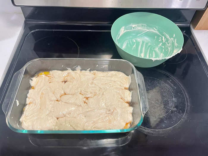 Pour the peaches and syrup into a pan before covering with the batter.