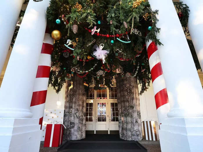 At the entrance to the East Wing of the White House, columns have been decorated to look like candy canes and Christmas tree trunks.