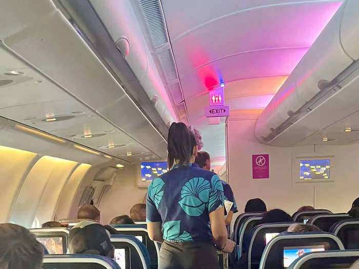 Walking through the cabin, I appreciated the light blue color scheme and the fun flight attendant uniforms.