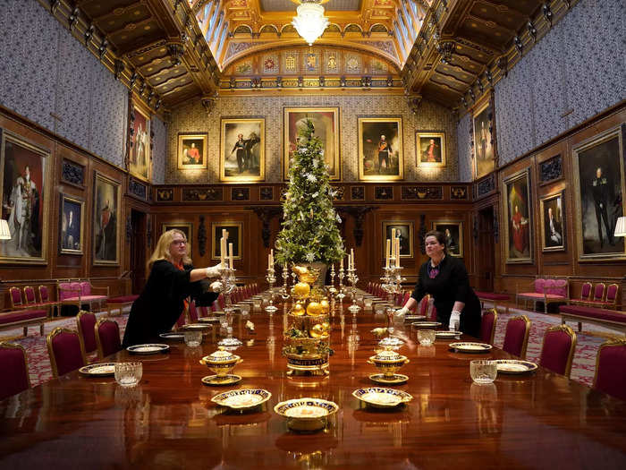 In the Waterloo Chamber, staff members set the table with porcelain dishes from the Garter Service.