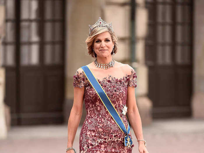 Attending a wedding in 2015, Queen Máxima wore a lace mermaid gown with an illusion neckline by Jan Taminiau. She also wore a diamond and ruby tiara, a matching choker necklace, and ruby drop earrings. 