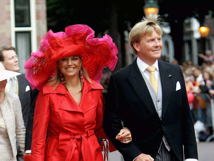 In one of her boldest looks to date, Máxima wore an oversized fascinator, a trench coat with a tie belt, and a pair of pink-and-red heels in 2005.
