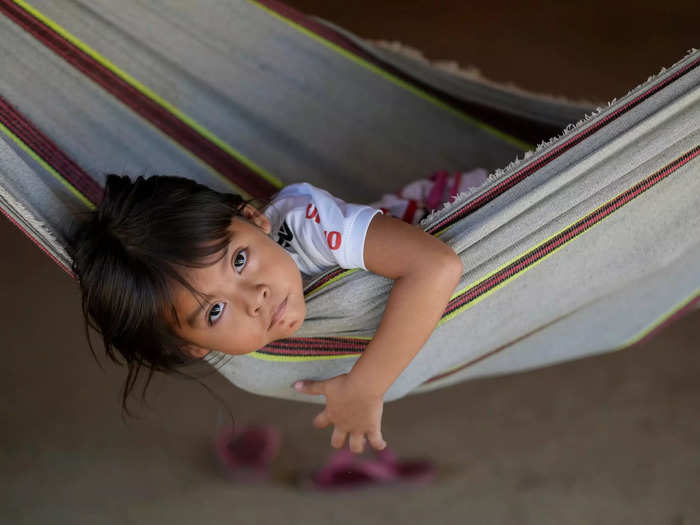 During the hottest parts of the day, the Juma gather at a community building called a maloca to relax in hammocks, eat, and tend to their birds. 