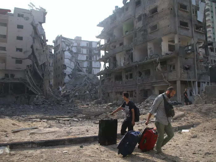 Palestinian citizens evacuated their homes damaged by Israeli airstrikes on October 10.