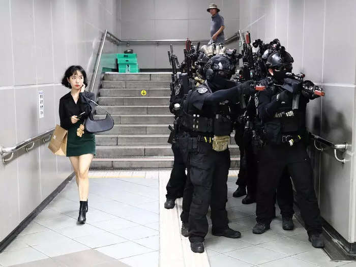 A woman walked past South Korean soldiers participating in an anti-chemical and anti-terror exercise in Seoul, South Korea.