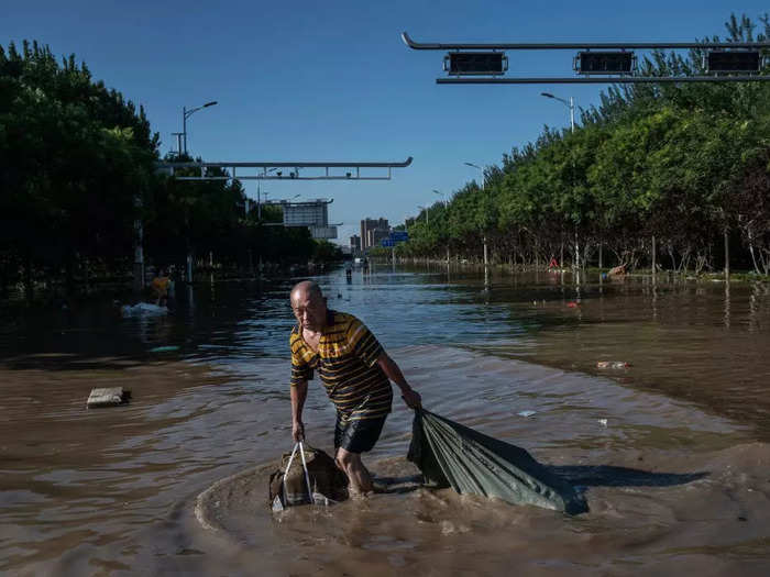 A man waded through floodwaters in Zhuozhou, China, on August 5.