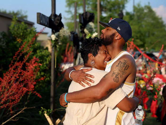 Robert Jackson comforted his mother, Cheryl Jackson, as they visit a memorial for a mass shooting at the Allen Premium Outlets mall on May 8 in Allen, Texas.
