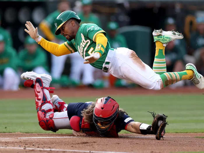 Tony Kemp of the Oakland Athletics jumps over Jorge Alfaro of the Boston Red Sox during a July 18 game in Oakland, California.