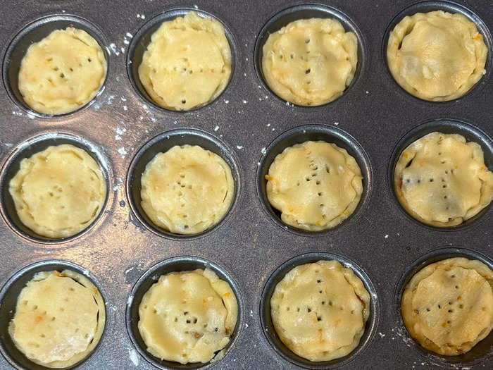 Wet the edges of each circle with some water, and firmly affix atop your mincemeat-loaded pastry cups. Prick with a fork on top. Then pop them in the oven for 10-15 minutes until they