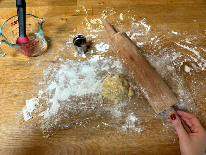 Then, pick up the remainder of your dough and repeat the process of rolling out the pastry to a 3-millimeter thickness in a parchment paper or cling wrap sandwich. Then, use the smaller cutter to cut 24 lids out of the pastry. 