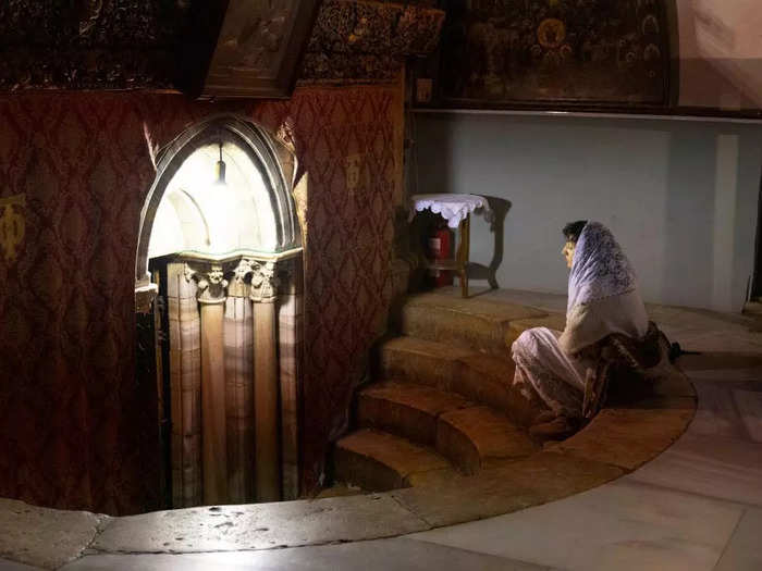 A lone worshipper sat in the grotto underneath the church