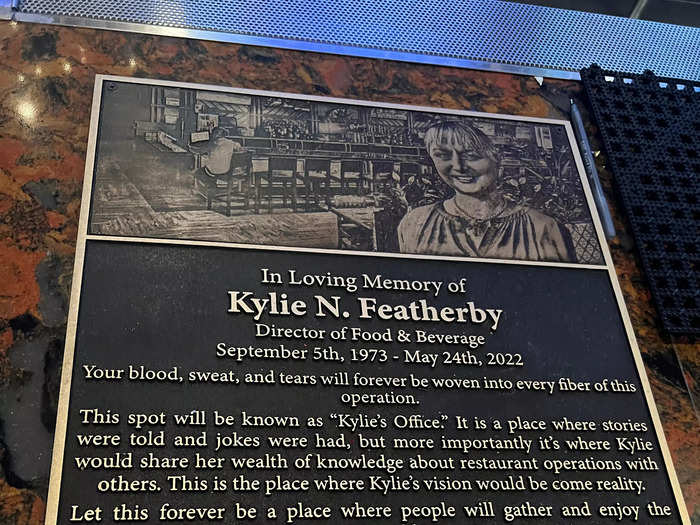 At one of the bars, a memorial plaque honoring Kylie Featherby, the food-and-beverage director, also includes Buffett