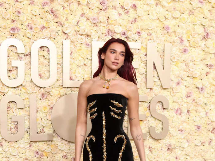 Dua Lipa wore a black dress covered in gold embellishments meant to look like bones. 