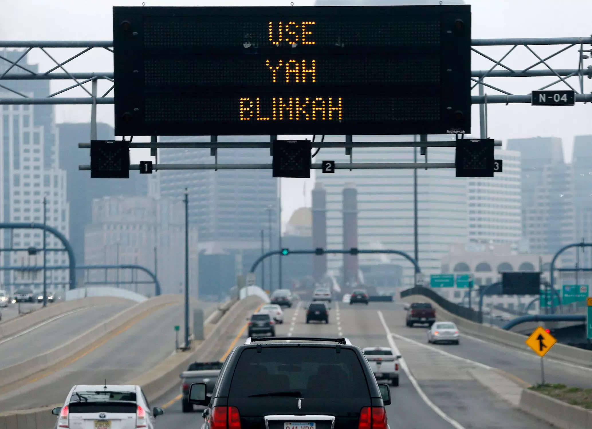 large black electronic sign reads "use yah blinkah" over a highway with cars