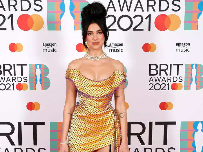 Lipa paired an asymmetrical dress with statement stockings for the 2021 Brit Awards.