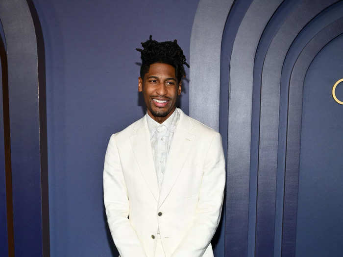 Jon Batiste wore an all-white ensemble consisting of a button-down blazer, matching pants, a collared shirt, and loafers.