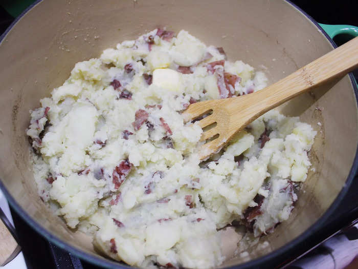 Then, drain the potatoes, mash them, and add in two tablespoons of butter or cream.