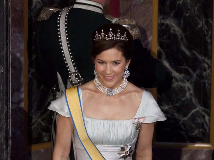 Attending a state banquet in 2009, Mary wore a ballgown with capped sleeves and a ruffled skirt. She accessorized with a tiara and rewore the pearl choker necklace.