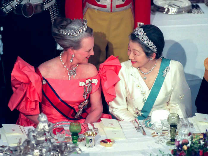 During a visit to Japan in 1998, Margrethe wore a  pink off-the-shoulder gown with dramatic ruffled sleeves, a pearl and diamond necklace, matching drop earrings, and a tiara.