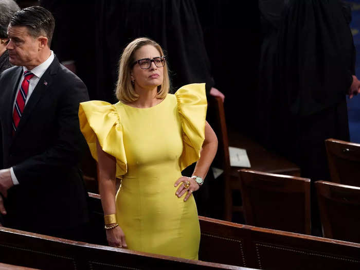 Sinema attended the 2023 State of the Union wearing a yellow sheath dress with dramatic ruffled sleeves.