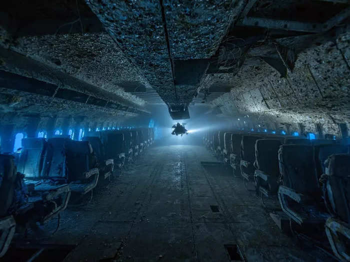 Another eerie view inside a sunken Lockheed passenger plane shows row upon row of unoccupied seats.