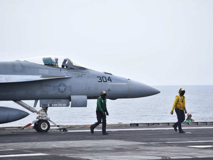 Fighter jets carrying heavy payloads are launched from one of the Ike