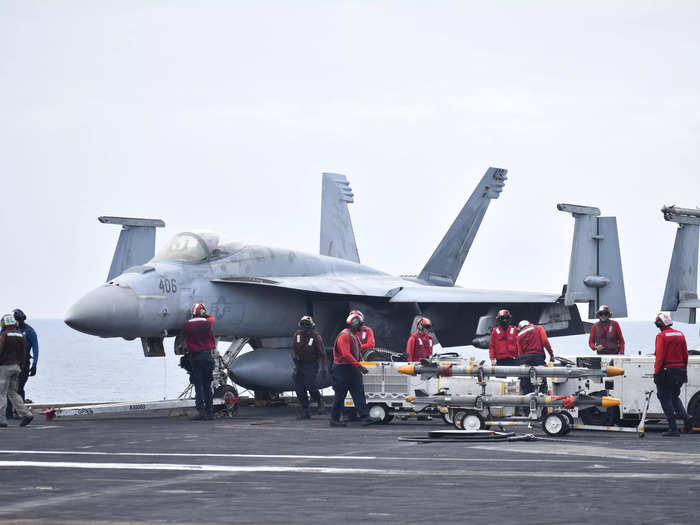 The personnel on the flight deck wear different colored vests to indicate their jobs, such as handlers, landing signal officers, arresting gear and catapult officers, and so on.