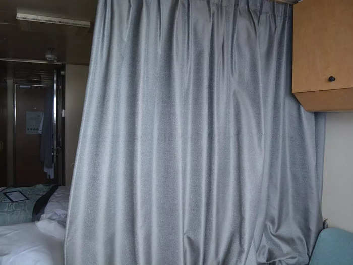 A curtain separated the two beds from the sitting area with the couch.