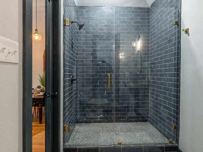 A second bathroom has matching blue tiles and a shower. 