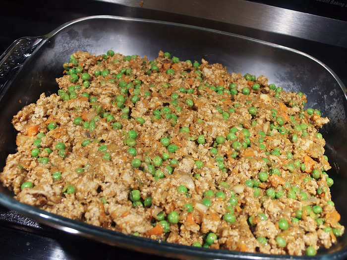 I added the pie filling to a large casserole dish and used a spoon to create an even layer of the meat and vegetables.