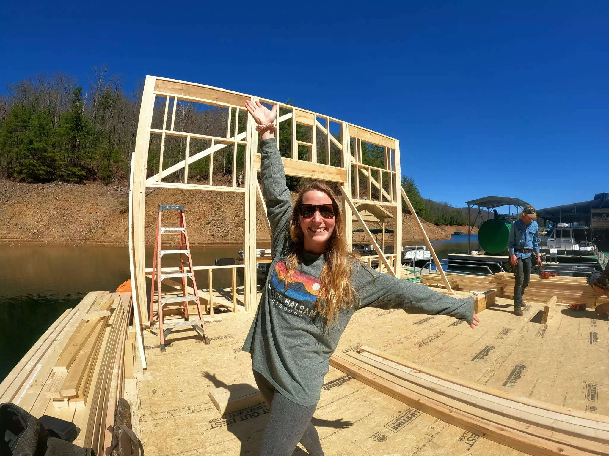 A woman posing on a floating platform during the construction of a floating home.