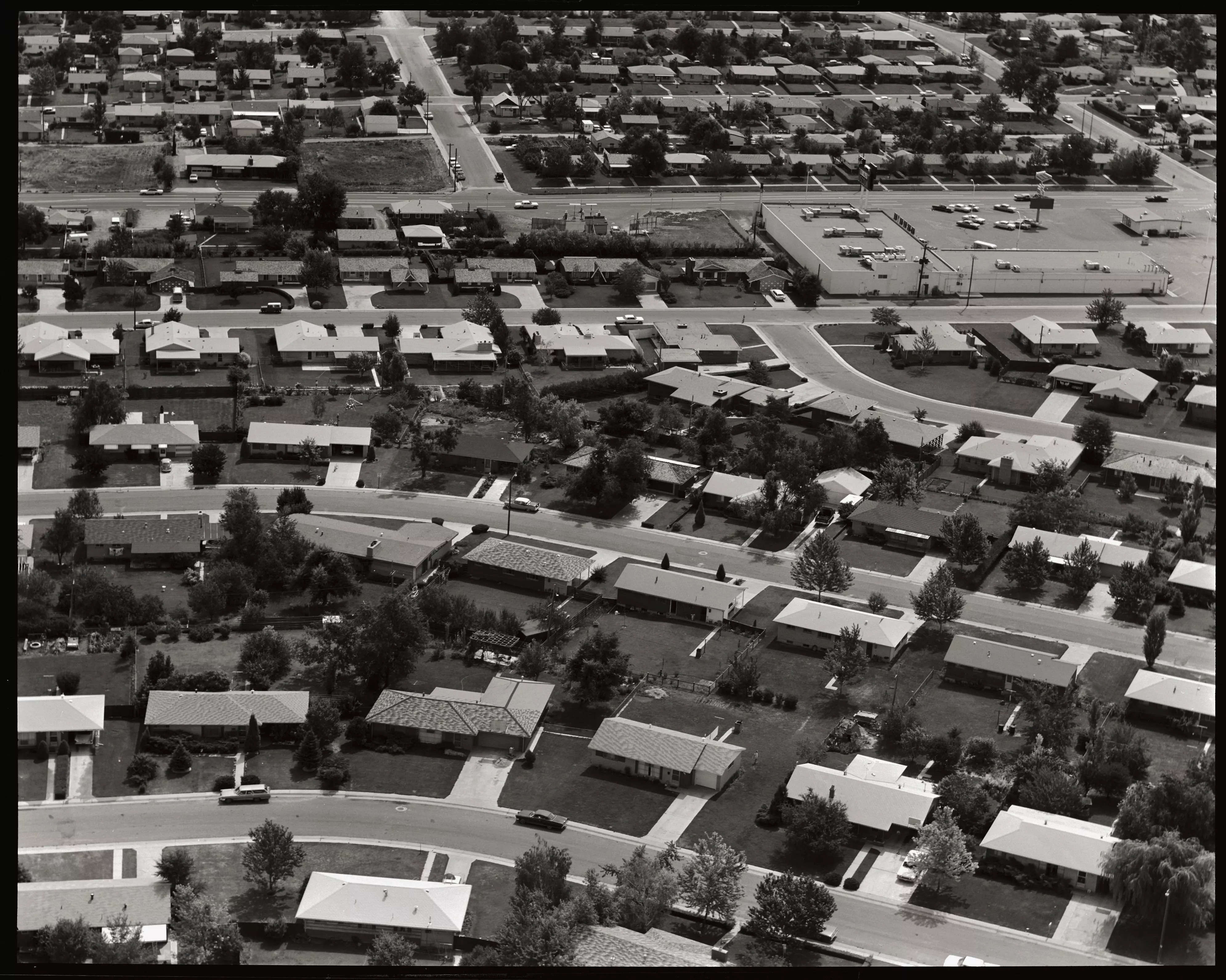 Tract homes in suburban development, homes, lawns, driveways and roads comprise a typical suburban neighborhood, circa 1967
